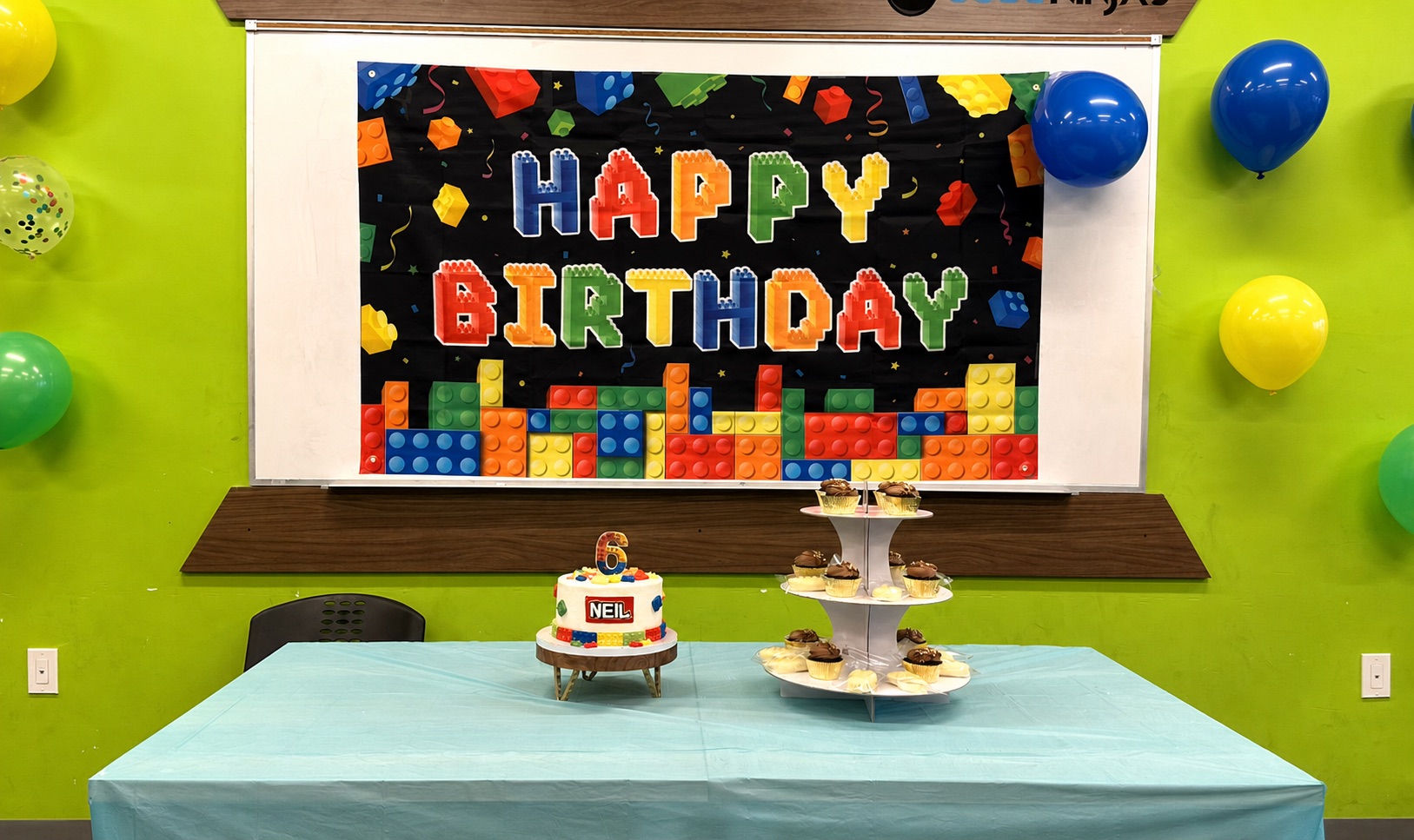 Birthday cake, cupcakes, balloons, and colorful celebration setup