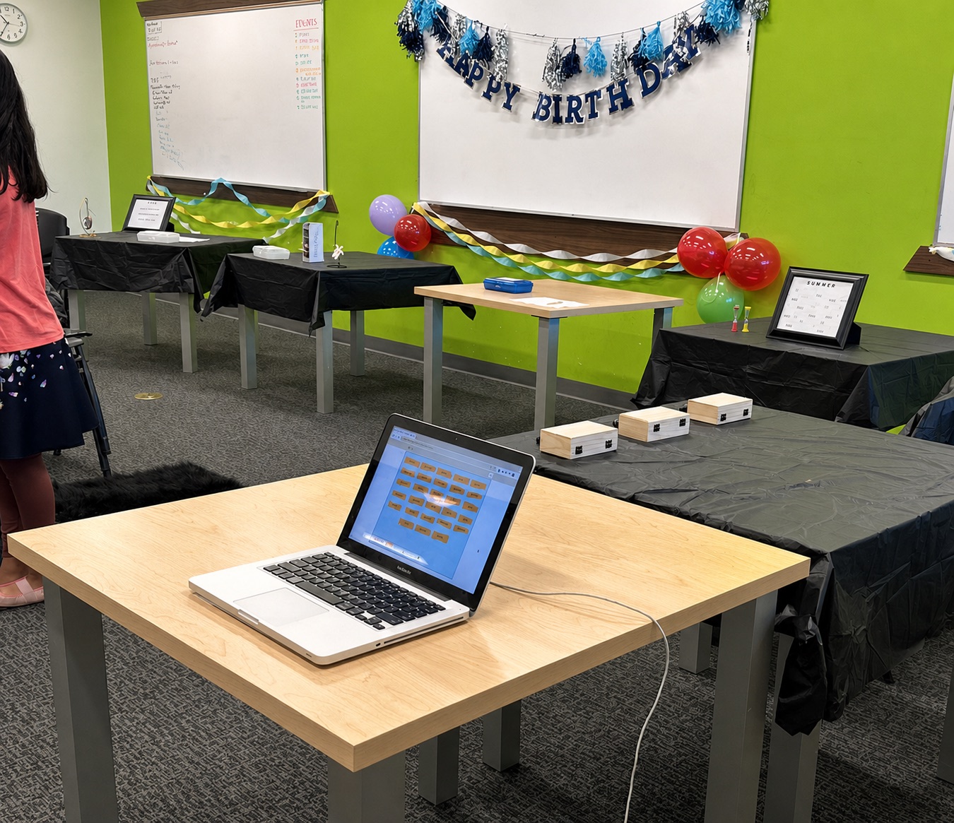 Laptop and activity tables prepared for hands-on STEM challenges